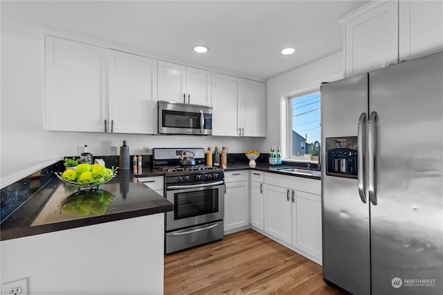 kitchen featuring white cabinetry, appliances with stainless steel finishes, sink, and light wood-type flooring