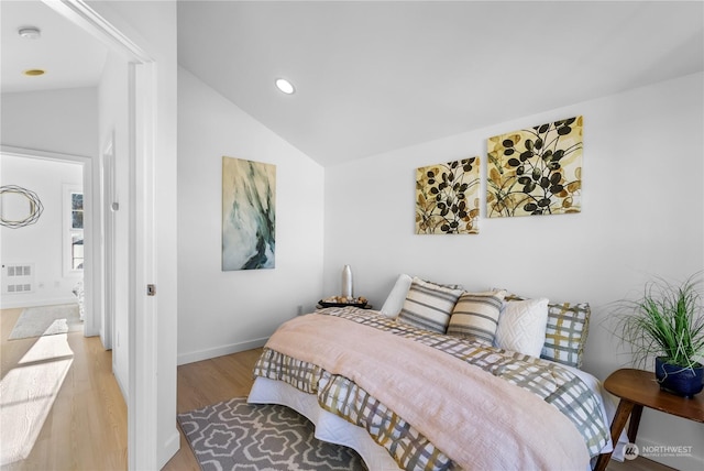 bedroom featuring lofted ceiling and light wood-type flooring