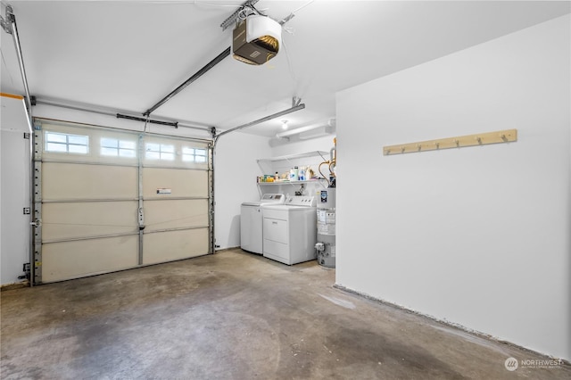 garage featuring water heater, washer and dryer, and a garage door opener