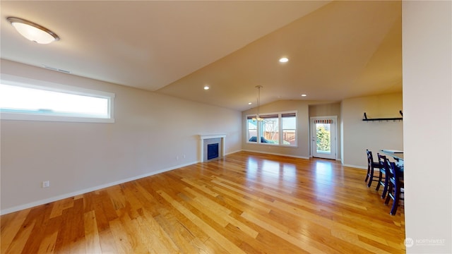 unfurnished living room with vaulted ceiling and light hardwood / wood-style floors