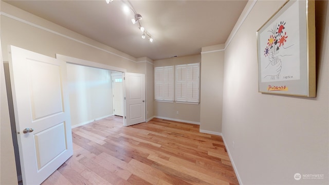 bedroom featuring track lighting and light hardwood / wood-style flooring