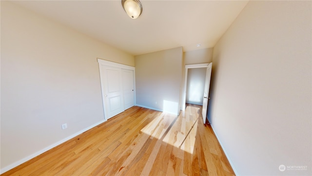 unfurnished bedroom with a closet and light hardwood / wood-style flooring