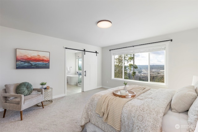 bedroom with light colored carpet, connected bathroom, and a barn door