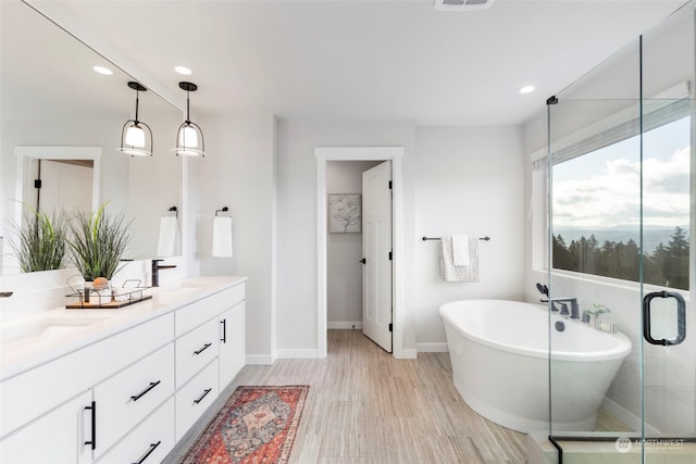 bathroom with vanity, hardwood / wood-style flooring, and shower with separate bathtub