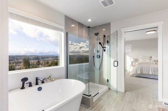 bathroom featuring independent shower and bath and a mountain view