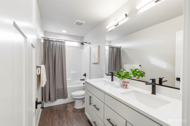 full bathroom featuring vanity, hardwood / wood-style flooring, toilet, and shower / bath combo