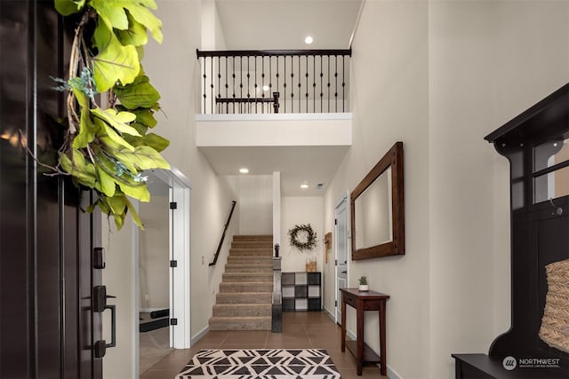 tiled foyer entrance with a towering ceiling