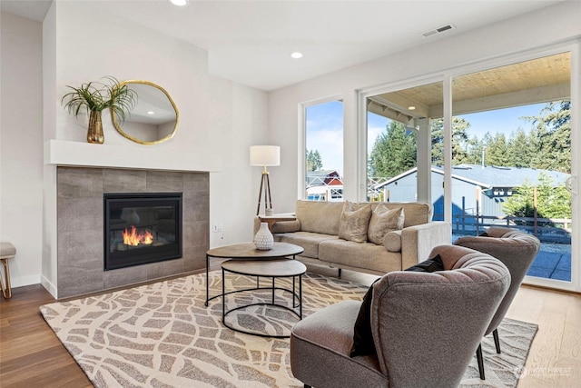 living room featuring hardwood / wood-style flooring and a tiled fireplace