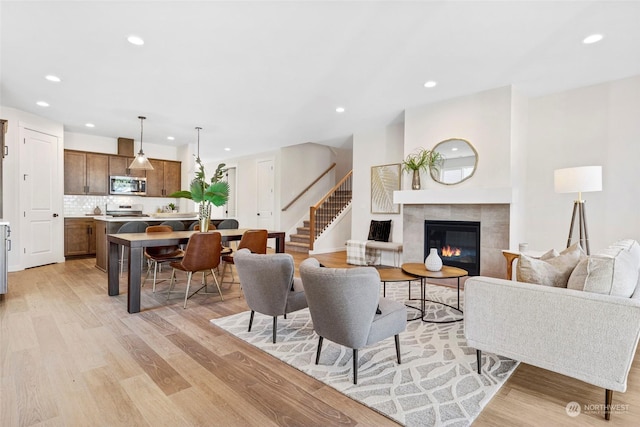 living room with light hardwood / wood-style flooring and a tile fireplace