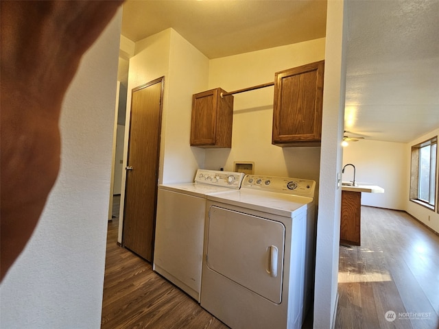 laundry room with washer and dryer, dark wood-type flooring, cabinets, and ceiling fan