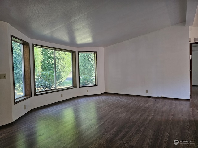 unfurnished living room with dark hardwood / wood-style flooring and a textured ceiling