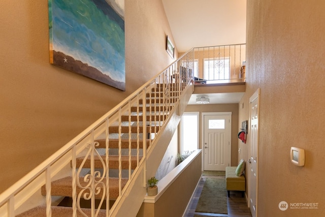 stairs featuring plenty of natural light and a high ceiling