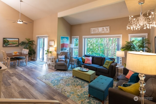 living room featuring wood-type flooring, ceiling fan with notable chandelier, and high vaulted ceiling