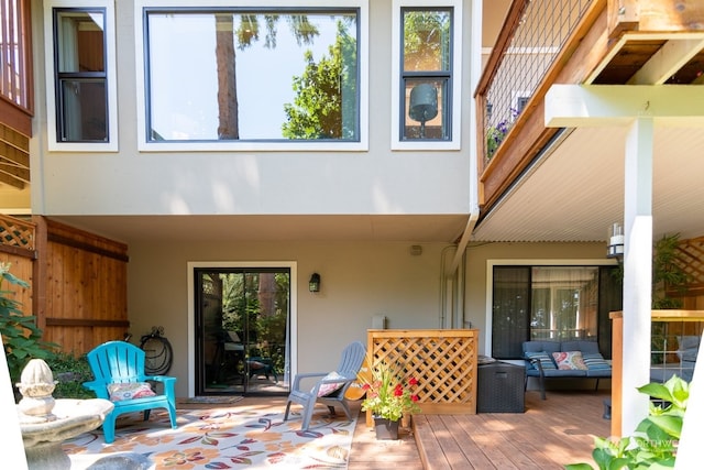 rear view of house with a wooden deck and outdoor lounge area