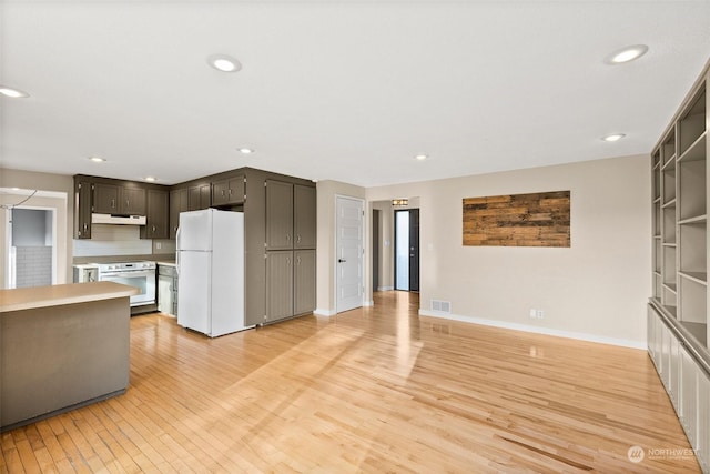 kitchen with light wood-type flooring, white appliances, and built in shelves