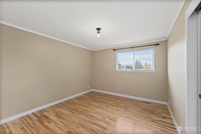 unfurnished room featuring ornamental molding and light hardwood / wood-style flooring