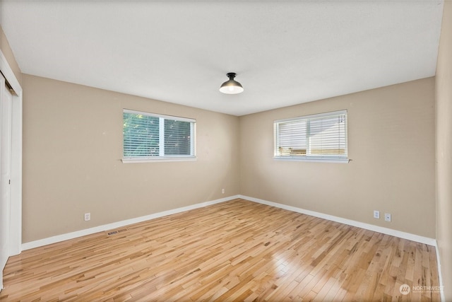 unfurnished room with a wealth of natural light and light hardwood / wood-style flooring