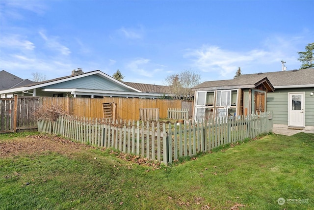 rear view of property with an outbuilding and a lawn