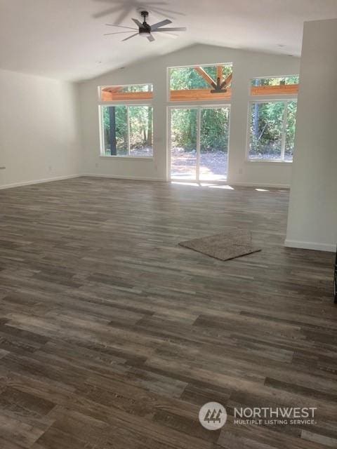 empty room with ceiling fan, dark wood-type flooring, a healthy amount of sunlight, and vaulted ceiling