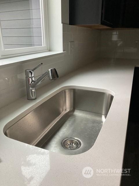 interior details featuring sink and decorative backsplash