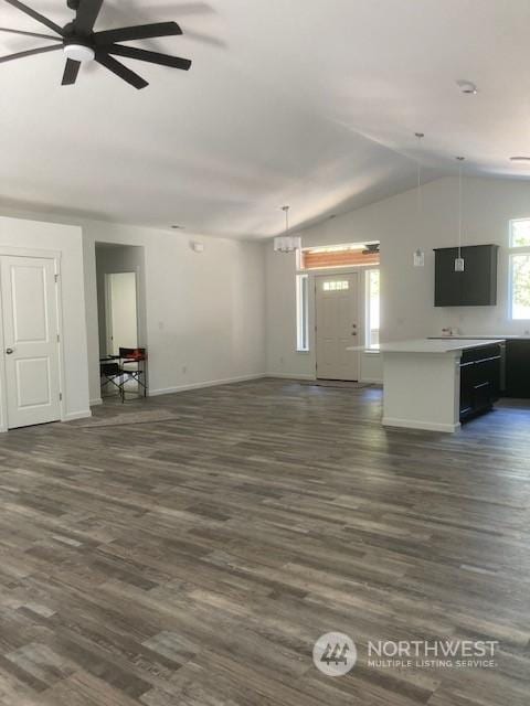 unfurnished living room featuring lofted ceiling, dark wood-type flooring, and ceiling fan