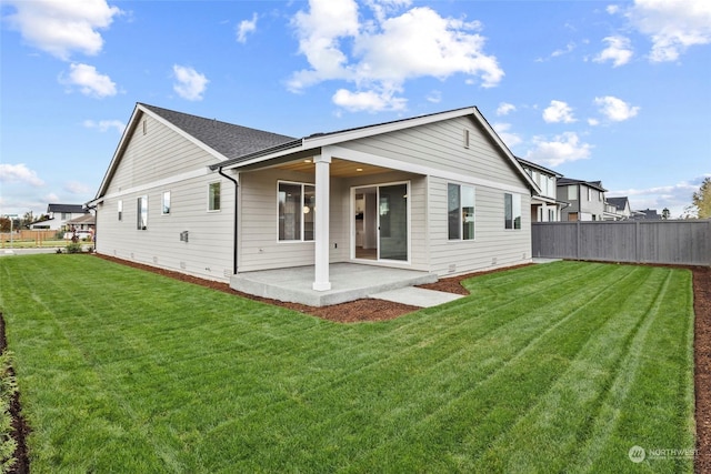 back of house featuring a patio and a lawn