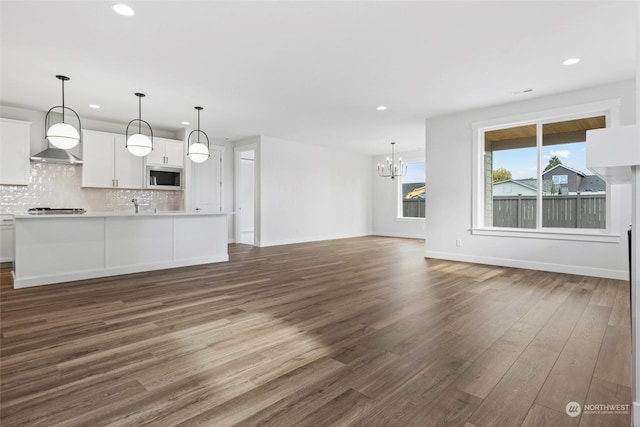 unfurnished living room featuring dark hardwood / wood-style floors and a chandelier