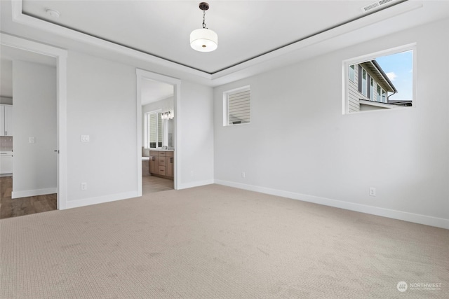 unfurnished bedroom featuring multiple windows, carpet floors, and ensuite bath