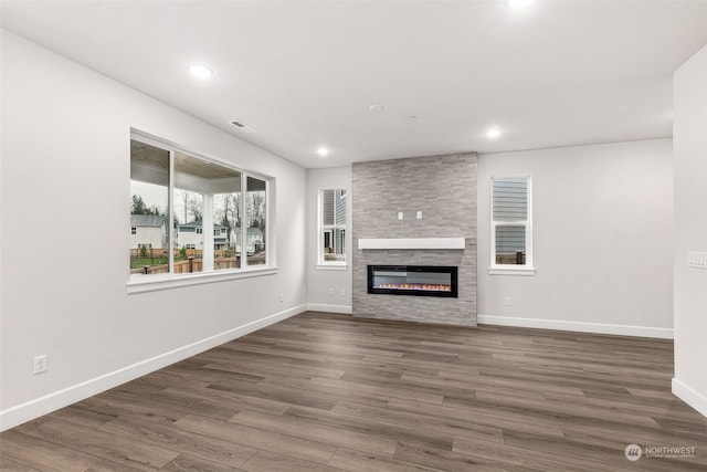 unfurnished living room featuring a fireplace and dark hardwood / wood-style floors