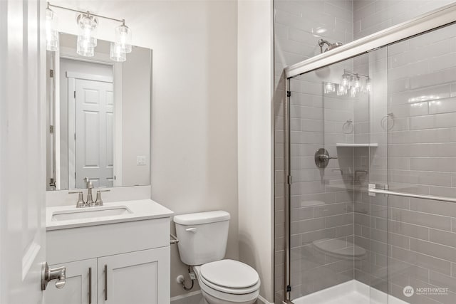 bathroom featuring vanity, toilet, and an enclosed shower