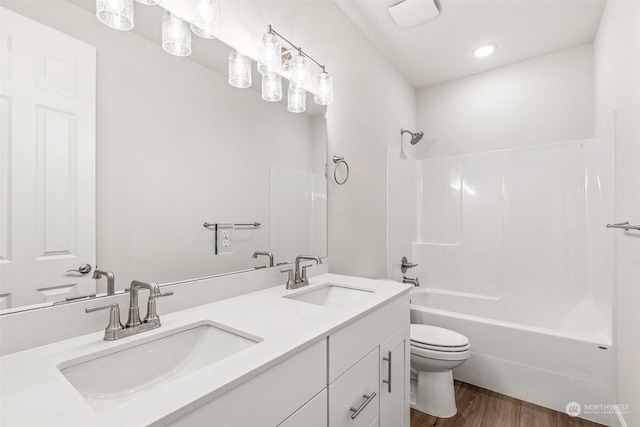 full bathroom with hardwood / wood-style flooring, vanity, toilet, and shower / bathing tub combination