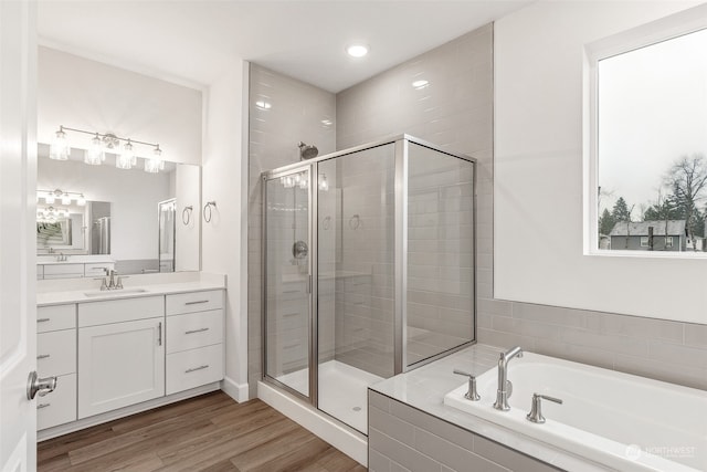 bathroom with shower with separate bathtub, hardwood / wood-style floors, and vanity