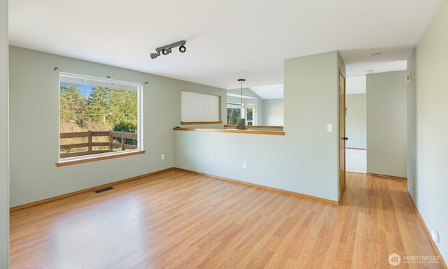 spare room featuring rail lighting, visible vents, and light wood finished floors