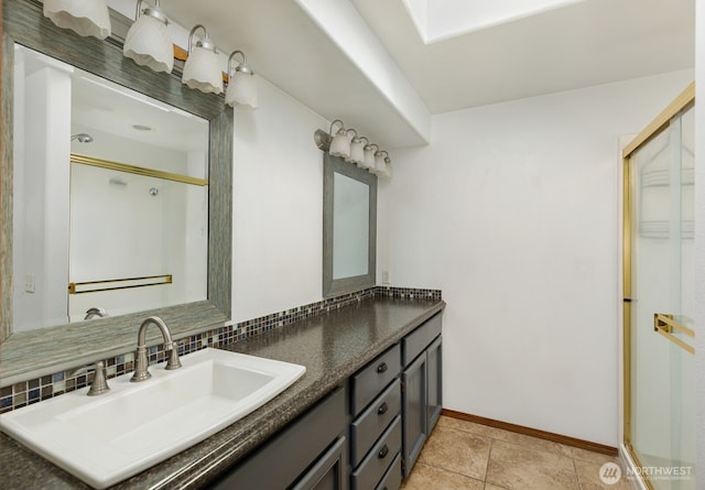 full bathroom with tasteful backsplash, tile patterned flooring, a shower with door, baseboards, and vanity