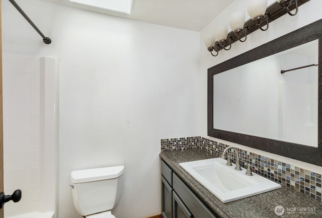 bathroom featuring decorative backsplash, toilet, vanity, and bathing tub / shower combination