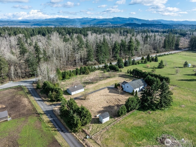 aerial view with a wooded view, a rural view, and a mountain view