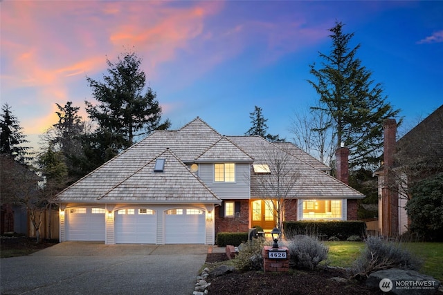 view of front of property featuring a garage, concrete driveway, and brick siding