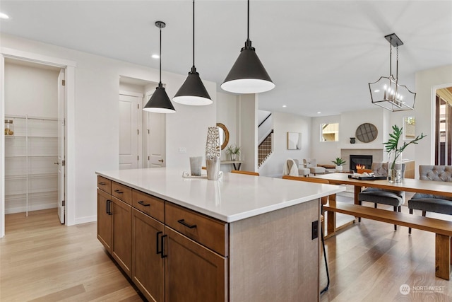 kitchen featuring hanging light fixtures, a kitchen island, and light hardwood / wood-style floors