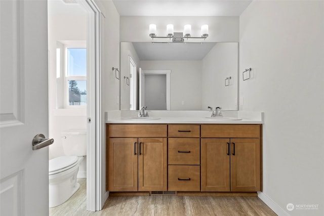 bathroom with hardwood / wood-style flooring, vanity, and toilet