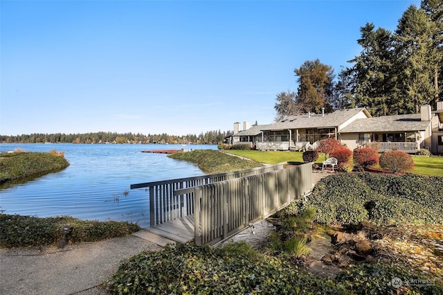 view of dock featuring a water view and a lawn