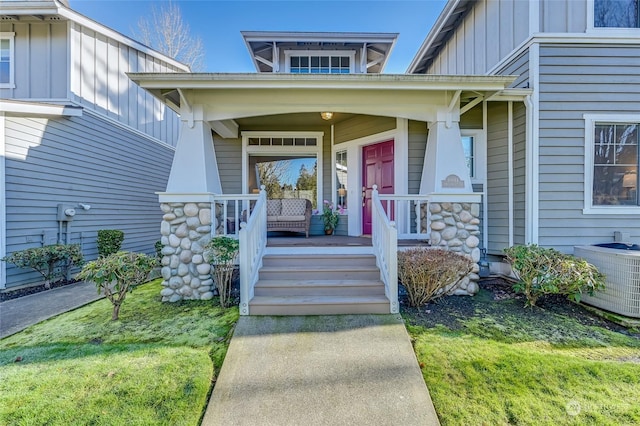 view of exterior entry with central AC unit and a porch