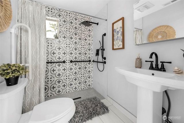 bathroom with a shower with curtain, toilet, tile patterned flooring, and sink