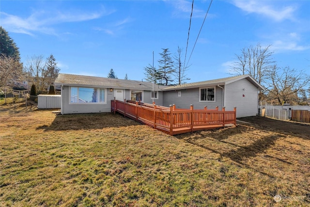 back of house featuring a wooden deck and a yard