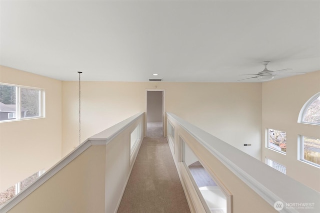 hallway featuring recessed lighting, visible vents, carpet flooring, and an upstairs landing