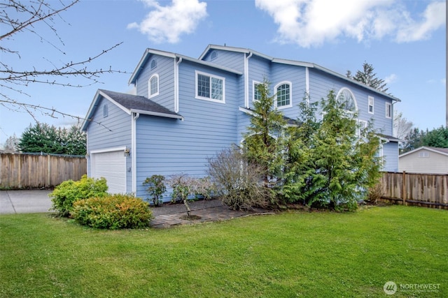 exterior space featuring a garage, a lawn, and fence