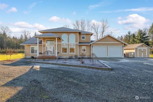 view of front of property featuring a garage and a storage unit