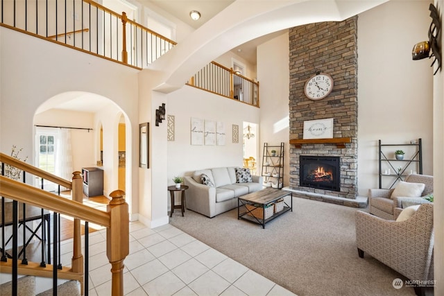 carpeted living room featuring a fireplace and a high ceiling