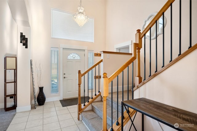 tiled foyer entrance with a notable chandelier and a high ceiling