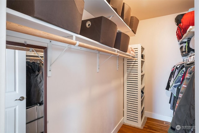 walk in closet with hardwood / wood-style floors