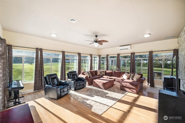 sunroom with an AC wall unit and ceiling fan